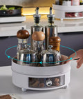 Обертовий органайзер для спецій з пляшками, баночками та висувним ящиком на кухонному столі.