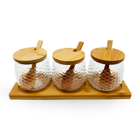 A set of glass jars with bamboo lids on a stand