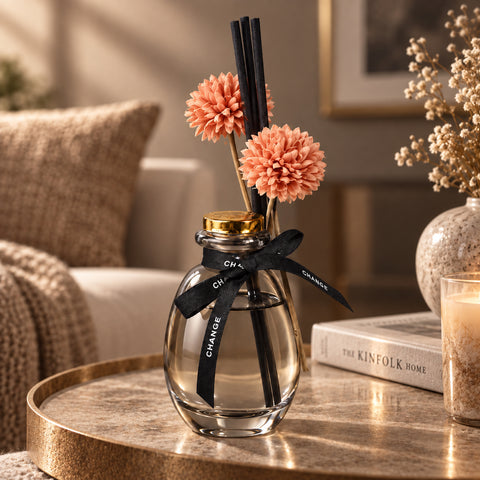 Димчастий аромадифузор з персиковими квітами на столі у вітальні