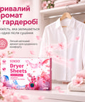 Біла сорочка та светри в шафі поруч з коробкою серветок Kelee з ароматом сакури